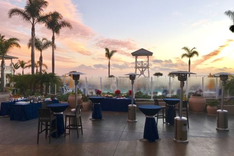 Outdoor event space with tables and heatlamps at sunset